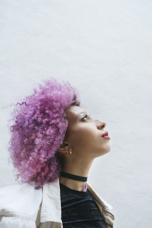 Stylish woman with pink hair looking at camera