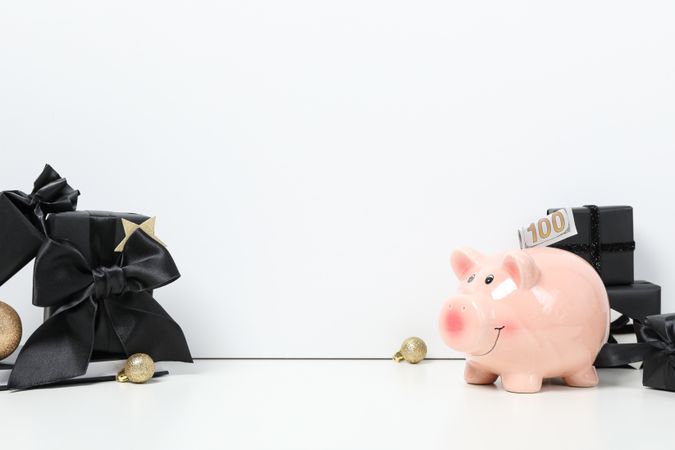 Piggy bank and gift boxes on light background, space for text