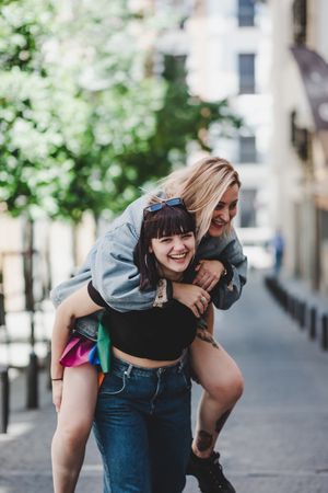 Happy lesbian couple having fun on street