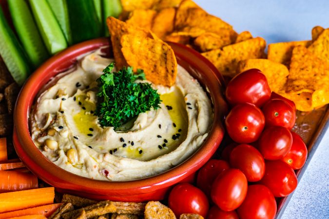 Traditional hummus dish served with fresh tomatoes and chips