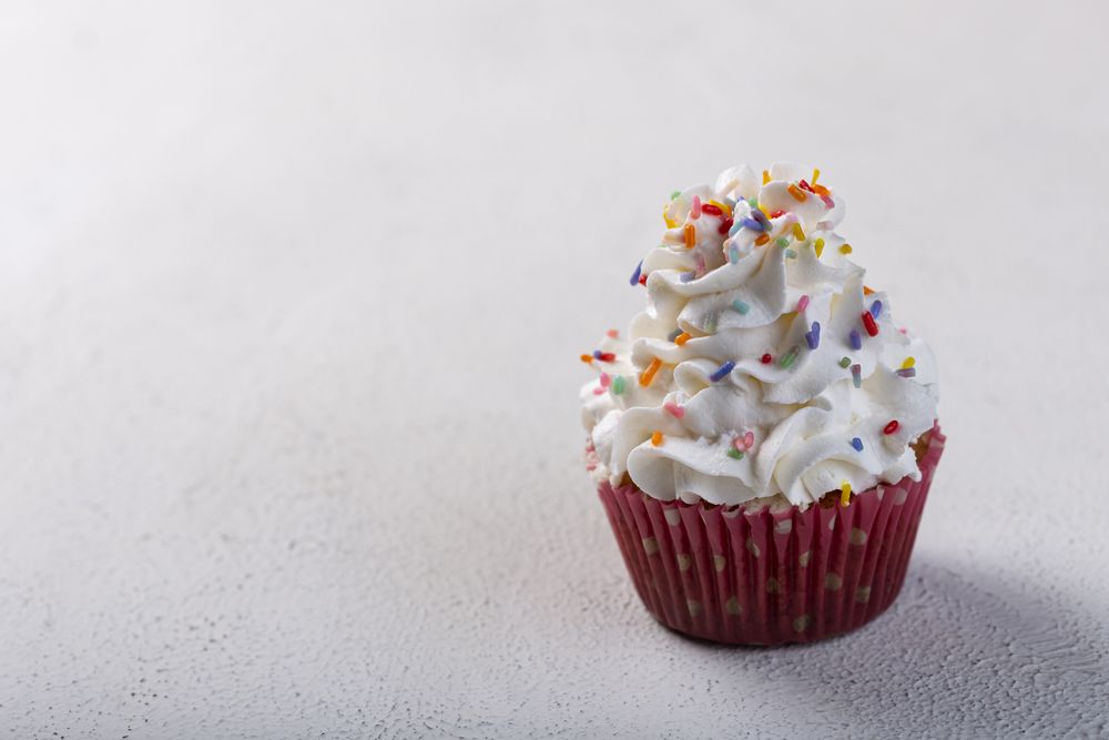 Tasty party cupcakes on the table. Cupcakes with whipped cream.