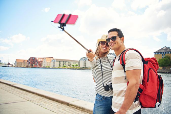 Cute couple using a selfie stick near a river
