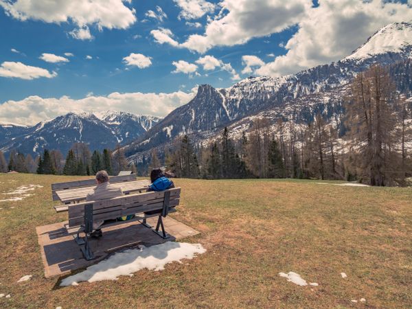 People sitting on bench in open air and looking at amazing landscape