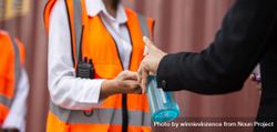 Staff receiving hand sanitizer on construction site bEDRN4