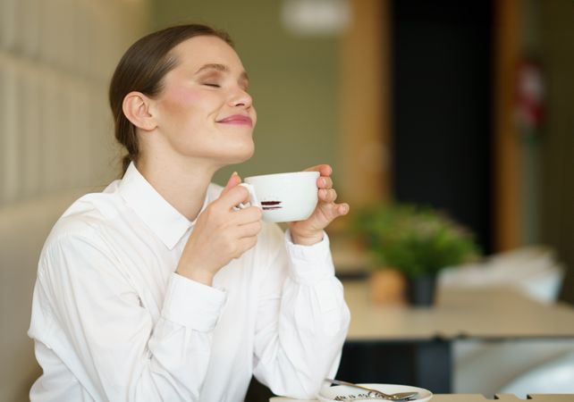 Young entrepreneur smiling enjoying coffee in a chic cafeteria