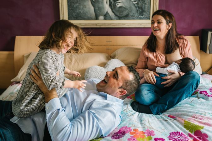 Happy family having fun in bedroom