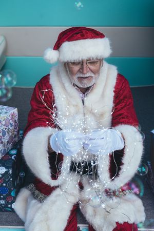 Santa Claus sitting with gifts and garland