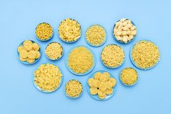 Pasta variety in blue plates above view on a blue table