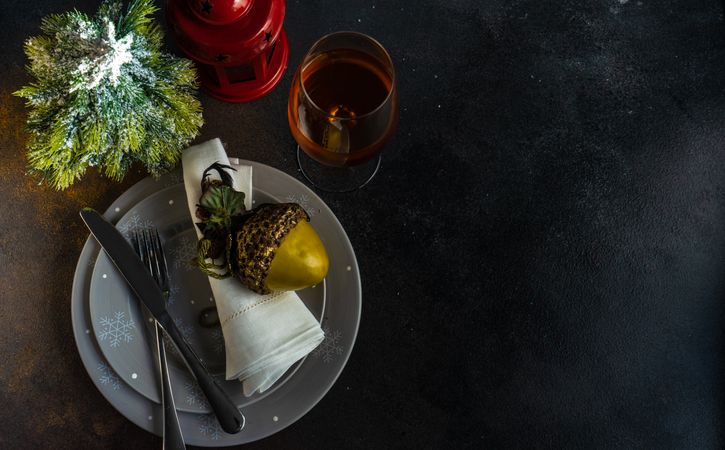 Top view of holiday table setting on grey plates with ornamental hazelnut