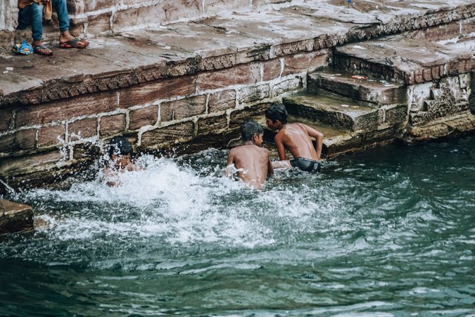 Back view of two boys in the river in Jodhpur, Rajasthan, India