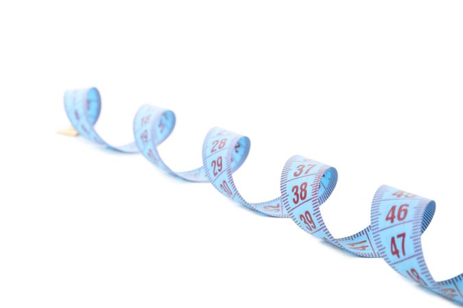 Measuring tape isolated on light background. Weight loss