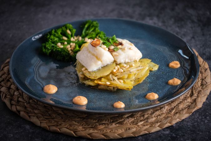 Appetizing gratin with fish served with sauce and broccoli