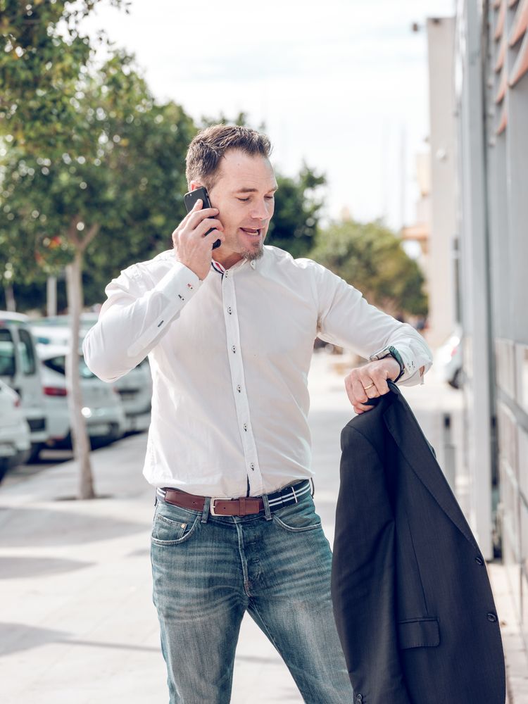 Punctual man checking time on wristwatch on street
