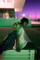 Loving couple sitting against vibrant sky