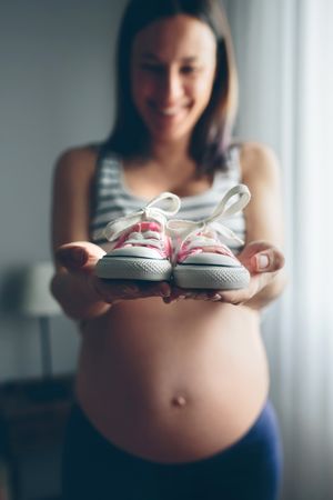 Baby sneakers held by pregnant