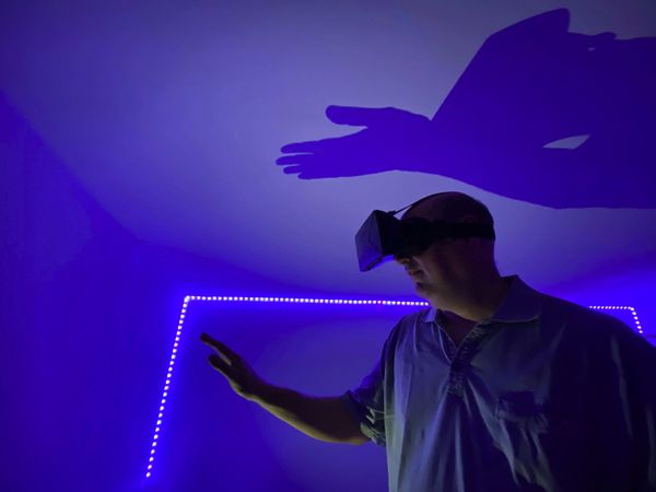 Side view of middle aged man wearing virtual reality headset indoor