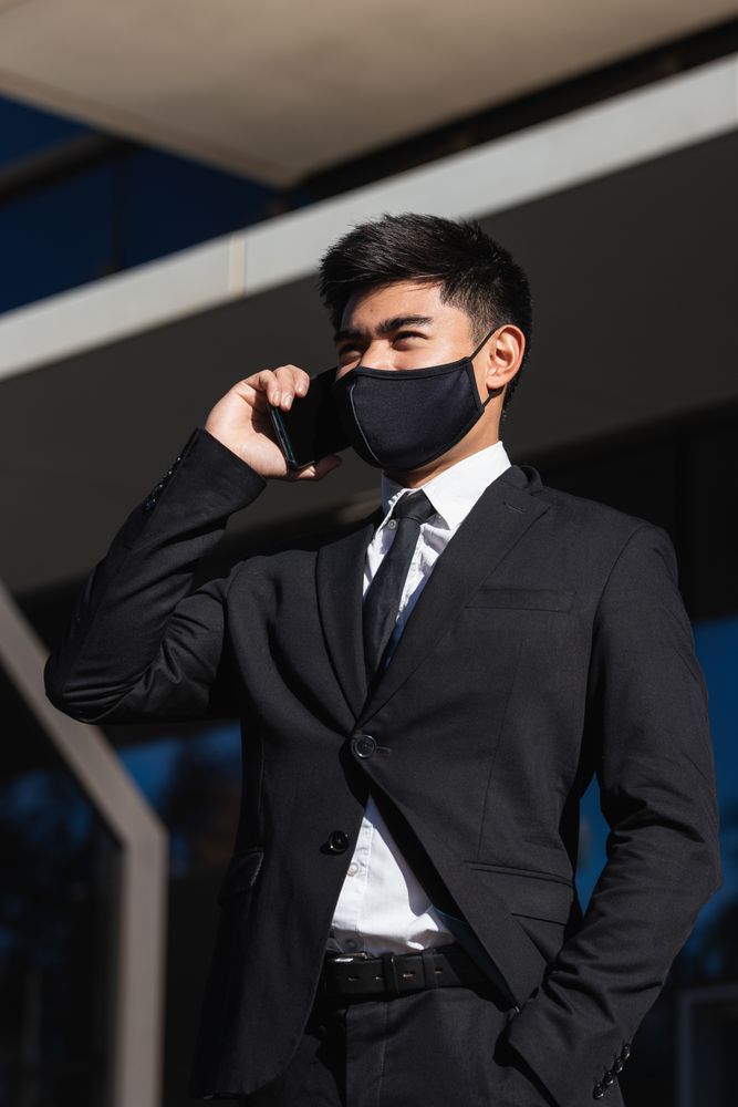 Serious male entrepreneur talking on smartphone in city