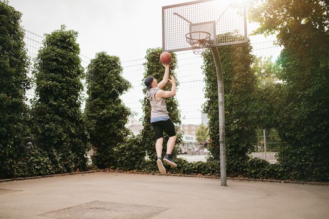 Man jumping to hoop playing streetball