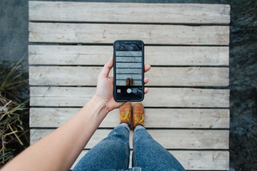 Woman taking photo of her feet with her phone