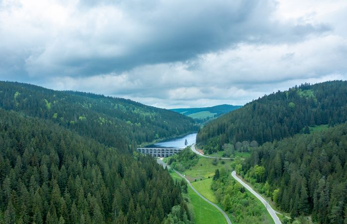 Drone image in Forest with water reservoir and evergreen trees.