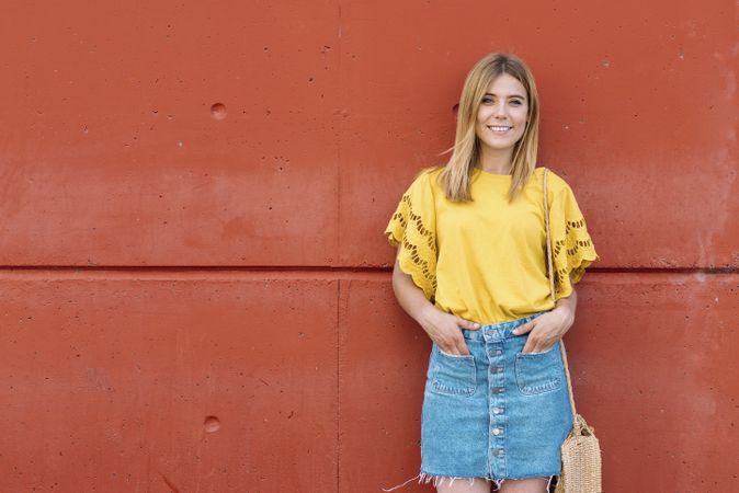 Cheerful woman standing on orange background