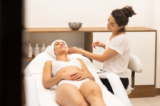 Woman having a face mask cleaned off professionally