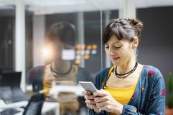 Woman browsing smartphone in office