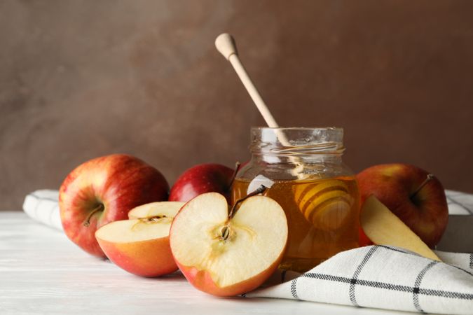 Side view of apples and honey on kitchen towel