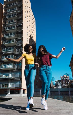 Two woman skipping in town