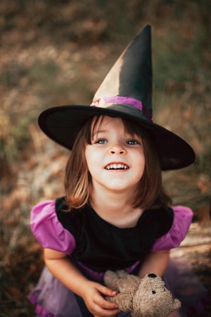 Happy girl looking up in witch costume