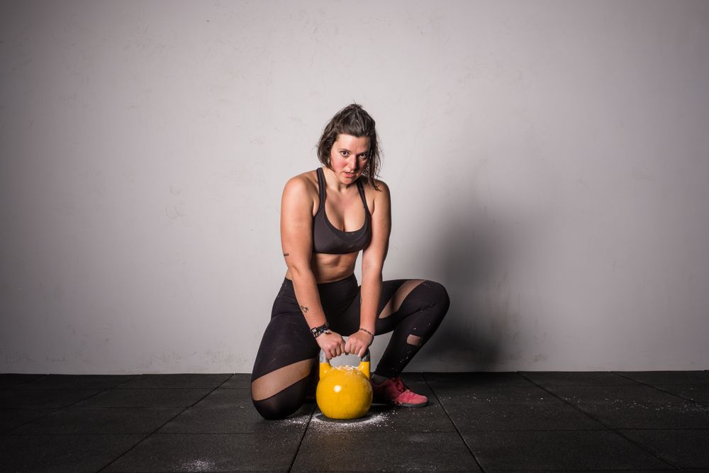 woman lifting kettlebell in gym