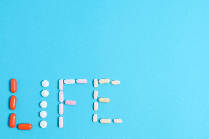 Multiple pills making the word "LIFE" with copy space