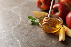 Apples and honey in kitchen with copy space