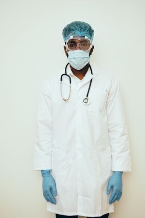 Portrait of Black male doctor in bright studio with full ppe gear ready for surgery on patient