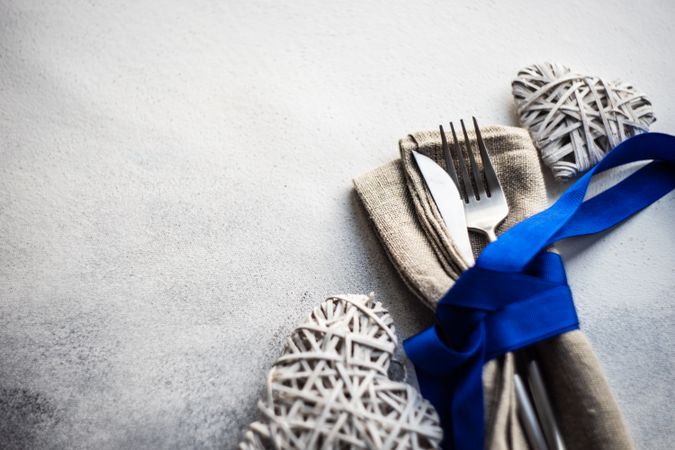 Blue ribbon wrapping cutlery with heart decorations