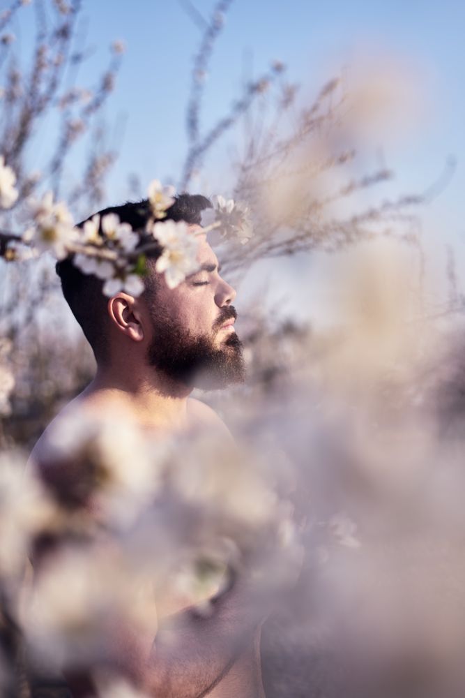 Shirtless man meditating in spring garden