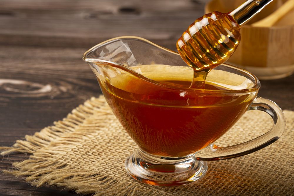 Honey in glass bowl on the table.