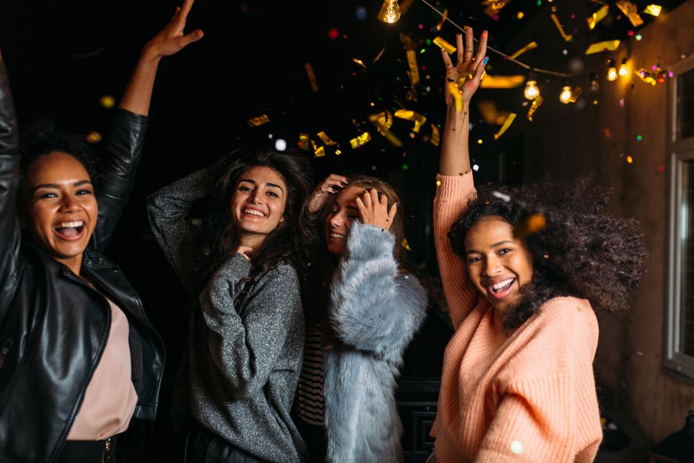 Multi-ethnic group of stylish women celebrating at night