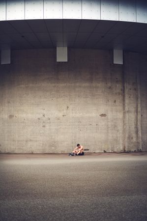 Shirtless man in large concrete space
