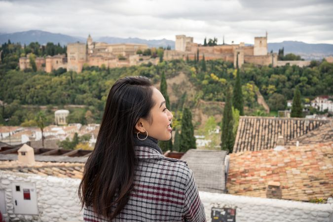 Content female enjoying view of big ancient castle