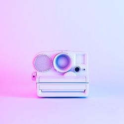 Front view of vintage camera painted in light paint on blue and purple background