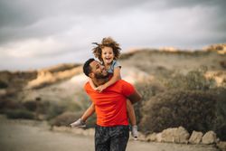 Black father holding child in arms