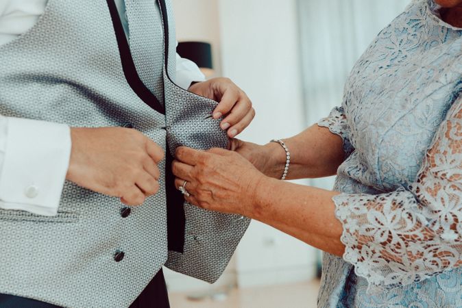 Woman buttoning up man waistcoat