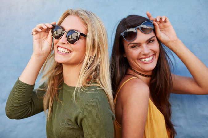 Best friends with sunglasses smiling and looking into camera