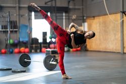 Flexible spoty woman kicking in the gym