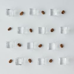 Coffee beans and ice cubes pattern on bright background
