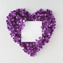 Purple confetti shaped in heart around paper card
