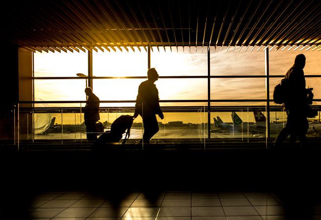 Silhouette of people walking in the airport at sunset