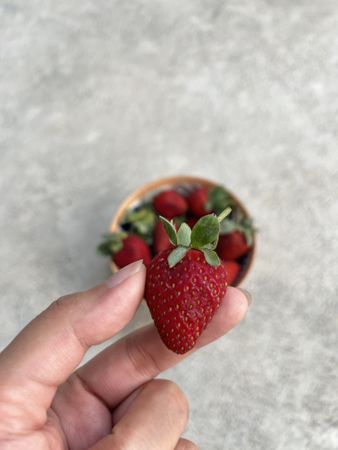 Holding strawberry with two fingers