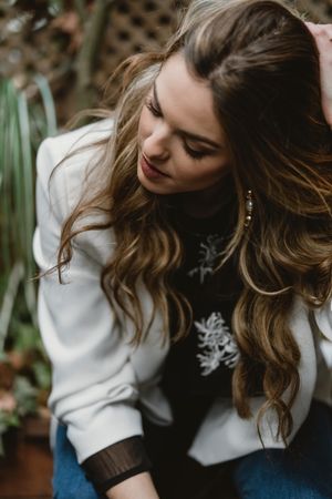 Woman sitting on planter in garden